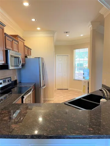 a kitchen with stainless steel appliances granite countertop a stove a sink and a refrigerator