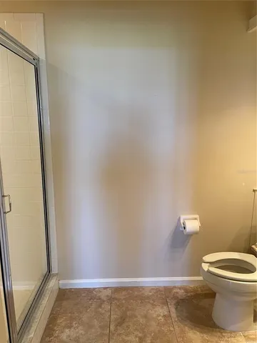 a white toilet sitting next to a shower