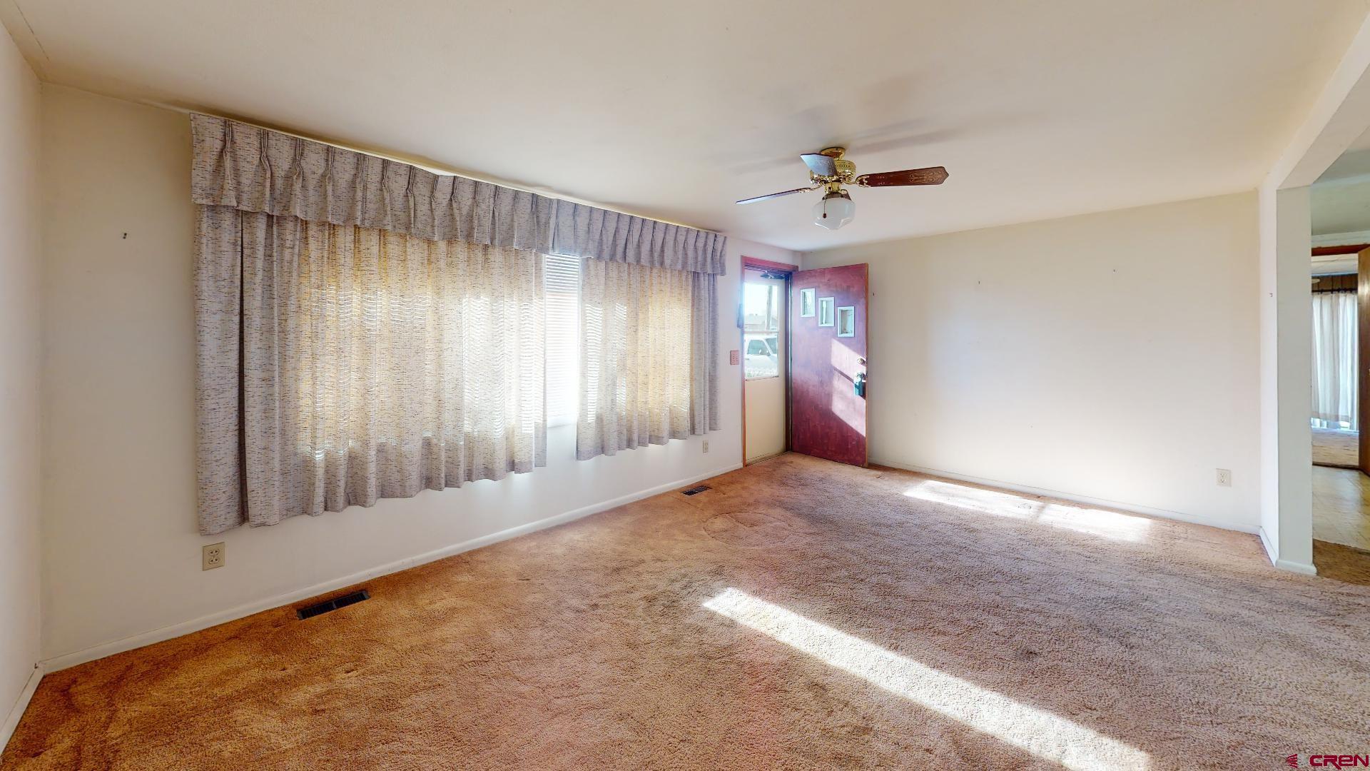 420 30 1/4 Road Grand Junction, CO 81504 - Photo 2 of 13 an empty room with windows and fan