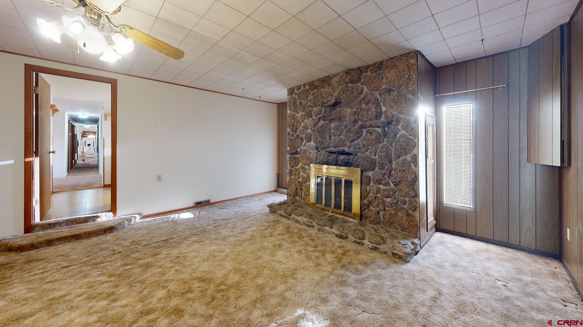 420 30 1/4 Road Grand Junction, CO 81504 - Photo 7 of 13 en empty room with a fireplace and chandelier