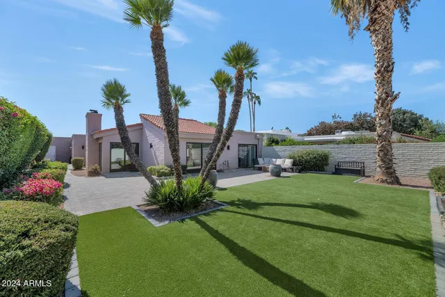 a view of backyard with outdoor seating and green space