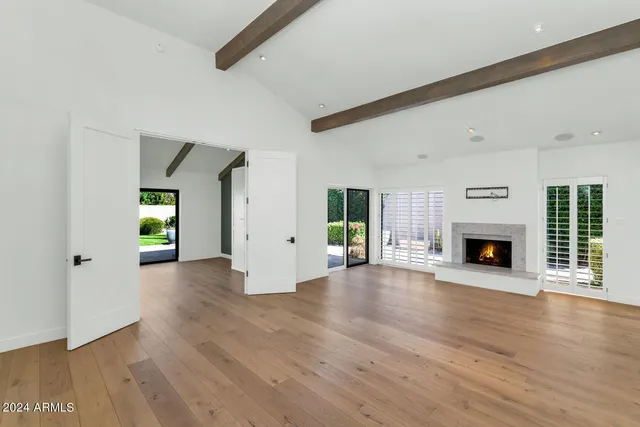 a view of a livingroom with wooden floor and a fireplace