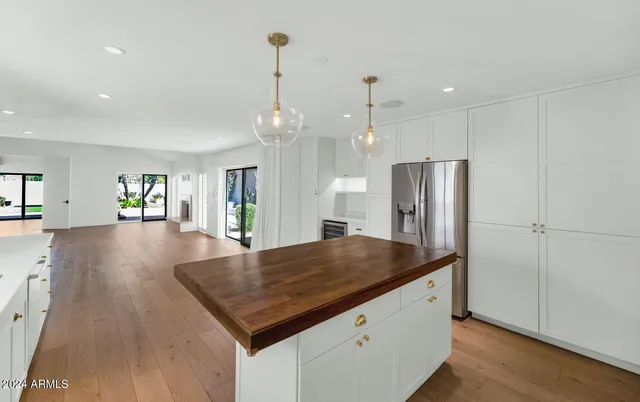 a kitchen with stainless steel appliances granite countertop a refrigerator a sink and a wooden cabinets