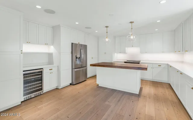 a kitchen with a refrigerator and white cabinets