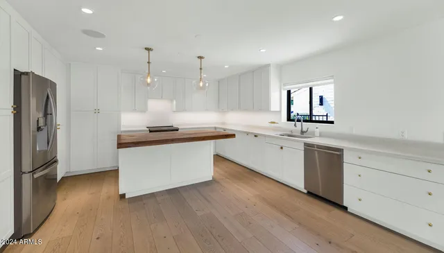 a kitchen with a sink cabinets and wooden floor