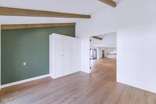 a view of a hallway with wooden floor and a living room