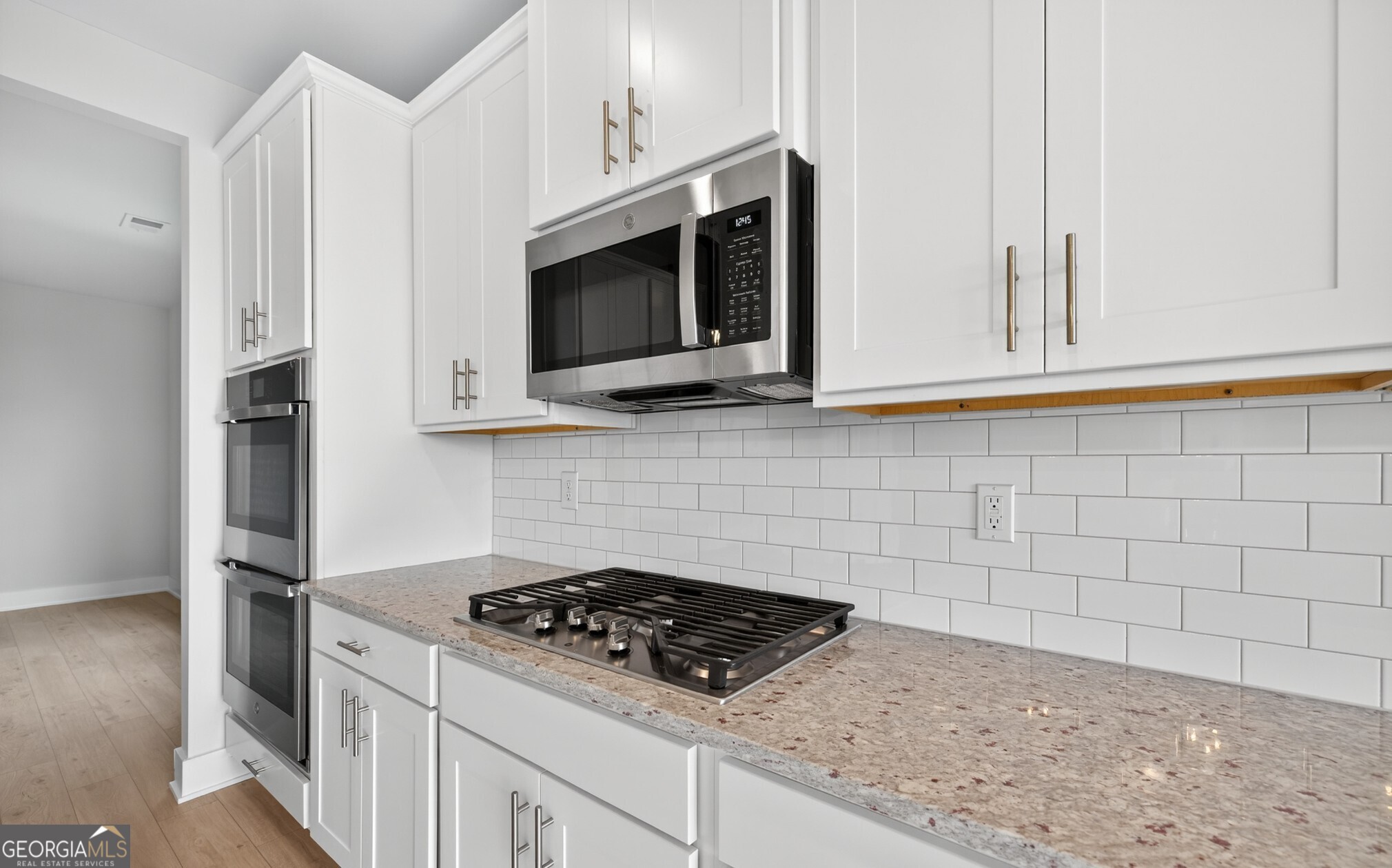 132 Patillo Manor, Unit 8 Stockbridge, GA 30281 - Photo 13 of 36 a kitchen with stainless steel appliances a stove a microwave and cabinets