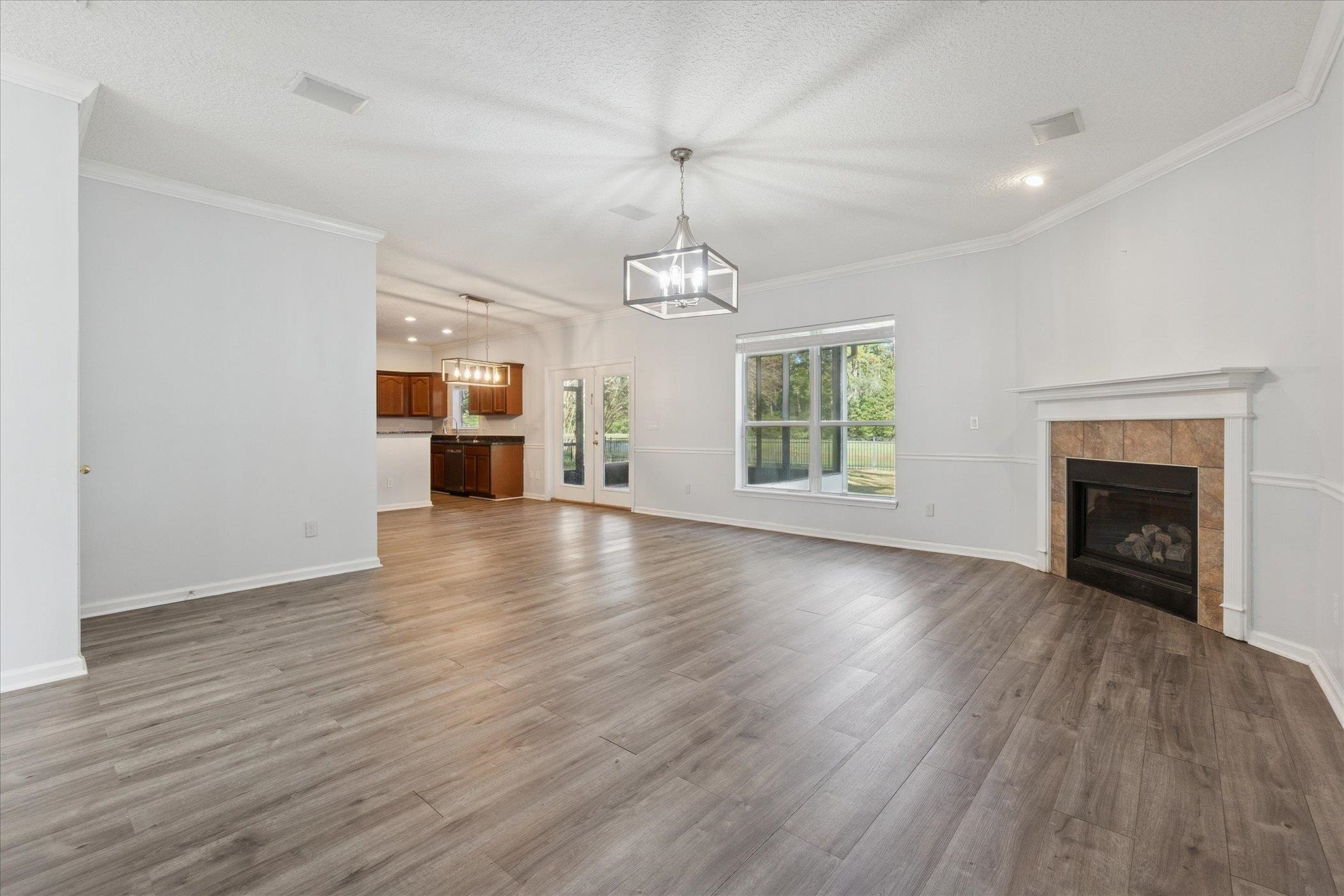 140 Corral Circle St. Augustine, FL 32092 - Photo 13 of 46 an empty room with wooden floor fireplace and windows