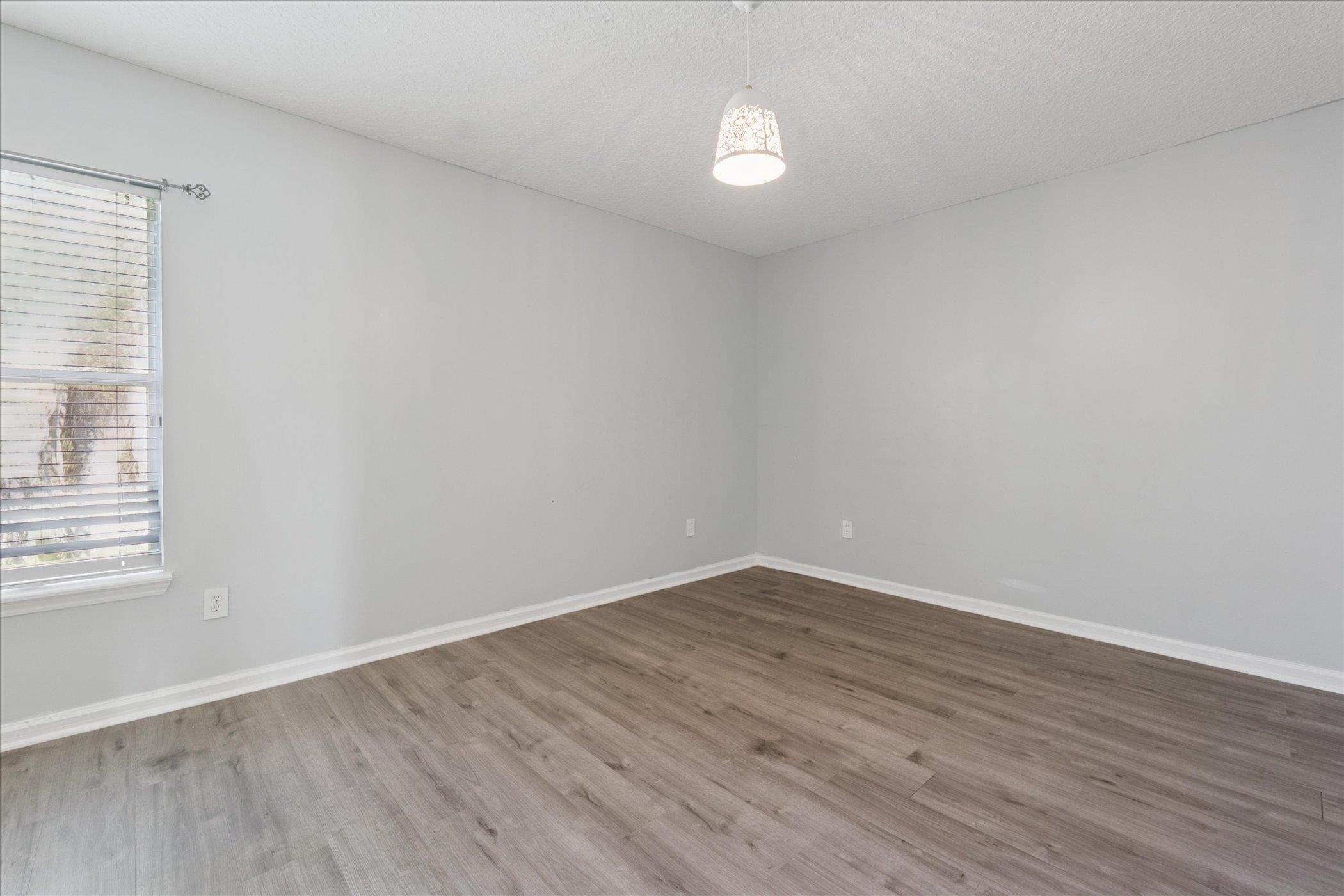 140 Corral Circle St. Augustine, FL 32092 - Photo 14 of 46 an empty room with wooden floor and windows