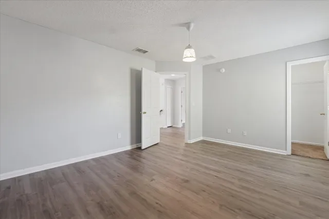 a view of an empty room with wooden floor
