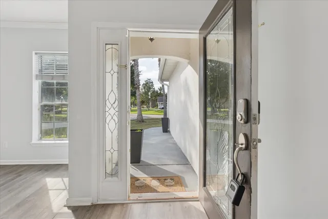a view of a hallway with wooden floor and living room
