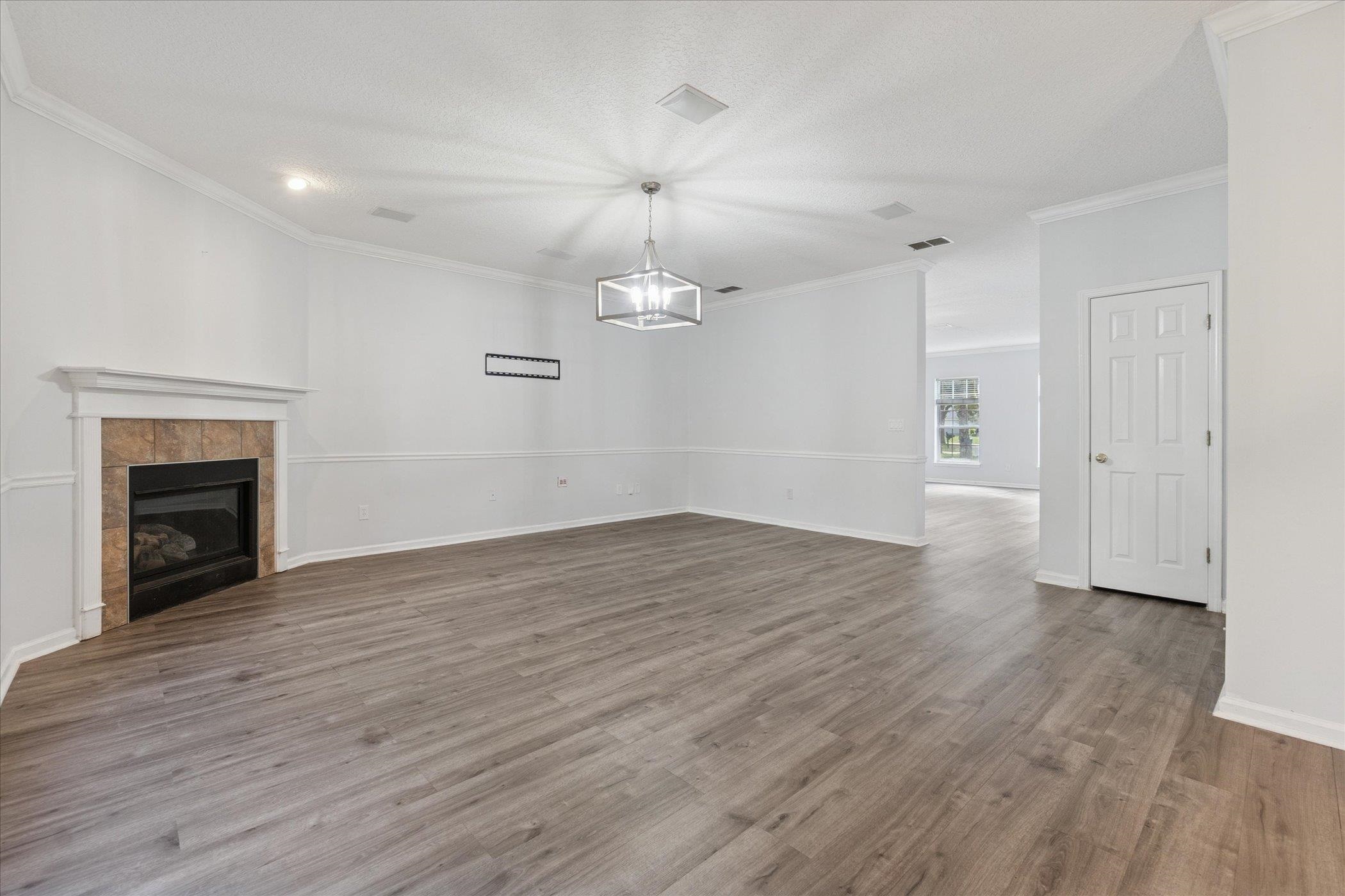 140 Corral Circle St. Augustine, FL 32092 - Photo 46 of 46 an empty room with wooden floor fireplace and windows