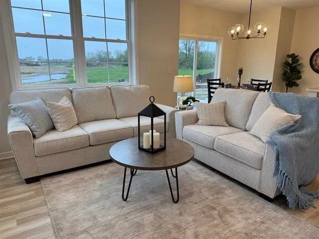 a living room with furniture a table and a large window