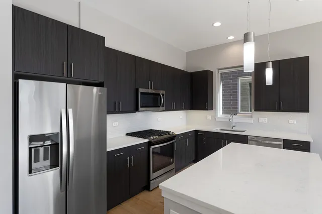 a kitchen with stainless steel appliances a refrigerator sink and microwave