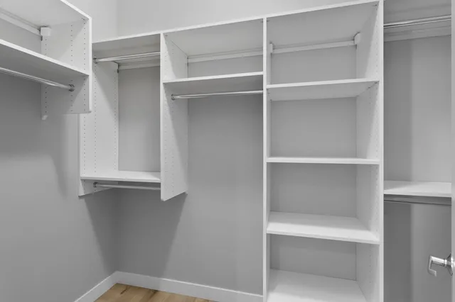 a view of walk in closet with empty racks