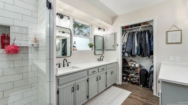 a bathroom with a double vanity sink and a mirror