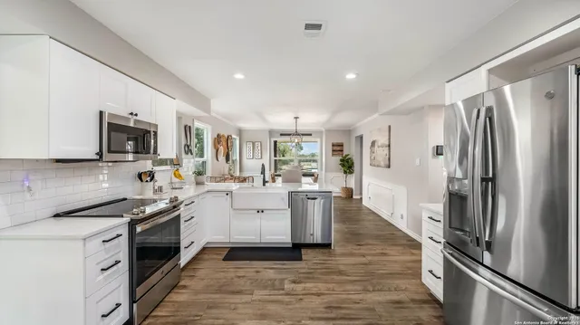 a kitchen with white cabinets and stainless steel appliances