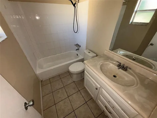a bathroom with a granite countertop sink a toilet and bathtub