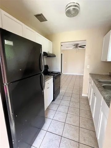 a kitchen with granite countertop a refrigerator and a sink
