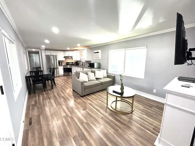 a living room with furniture a flat screen tv and a table