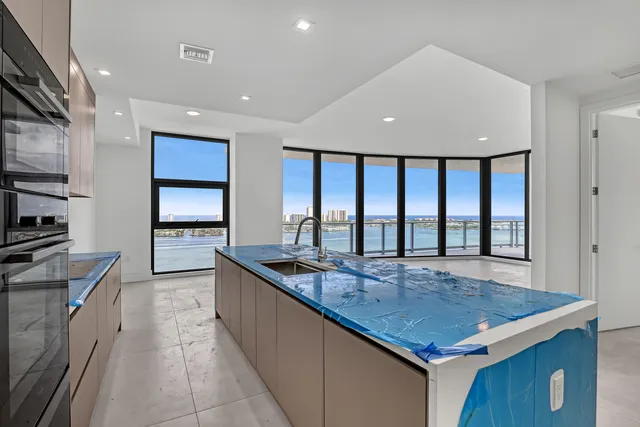 a view of an empty room with kitchen view and a window