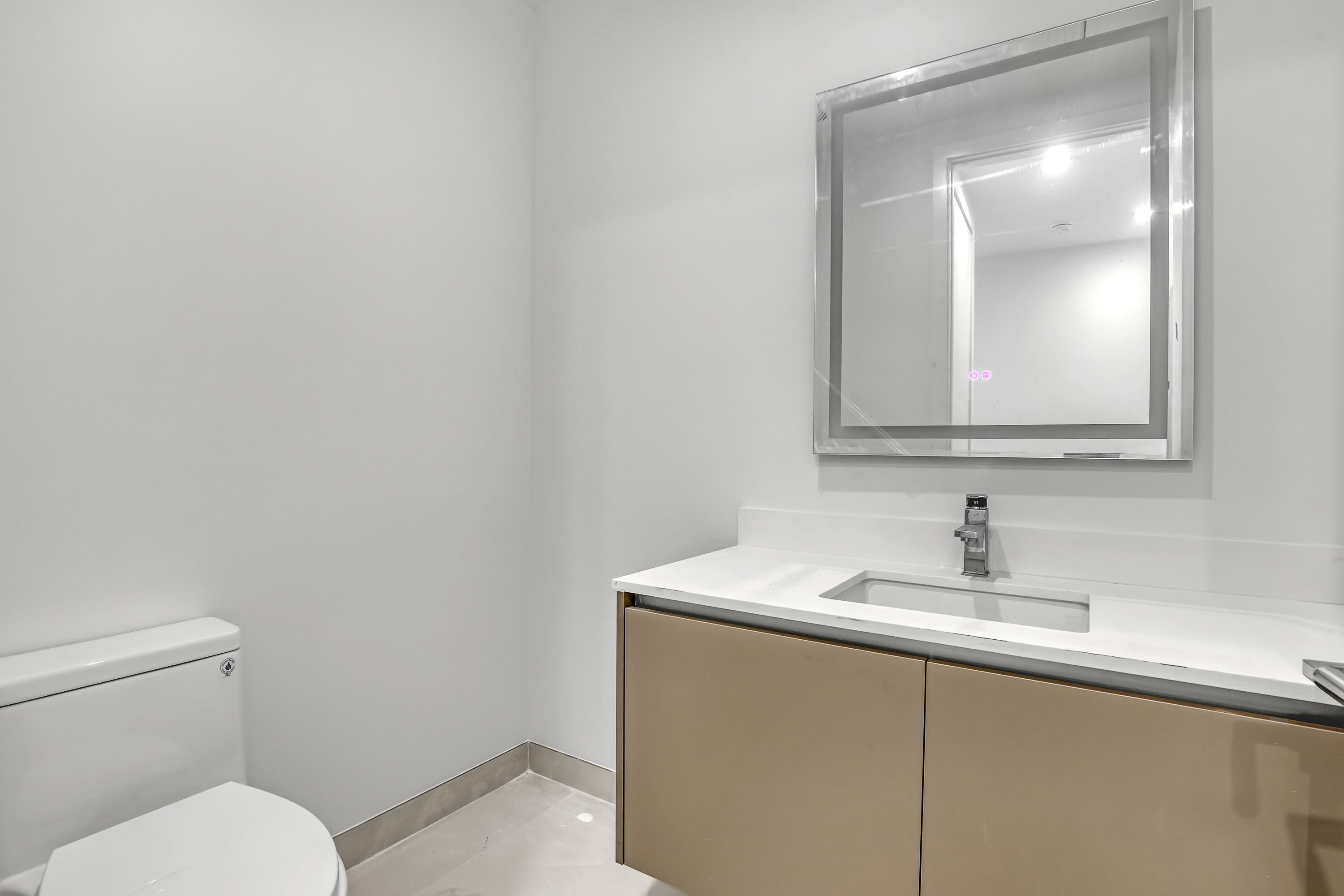 220 Lake Shore Drive, Unit N2103 Lake Park, FL 33403 - Photo 39 of 57 a bathroom with a toilet sink and mirror