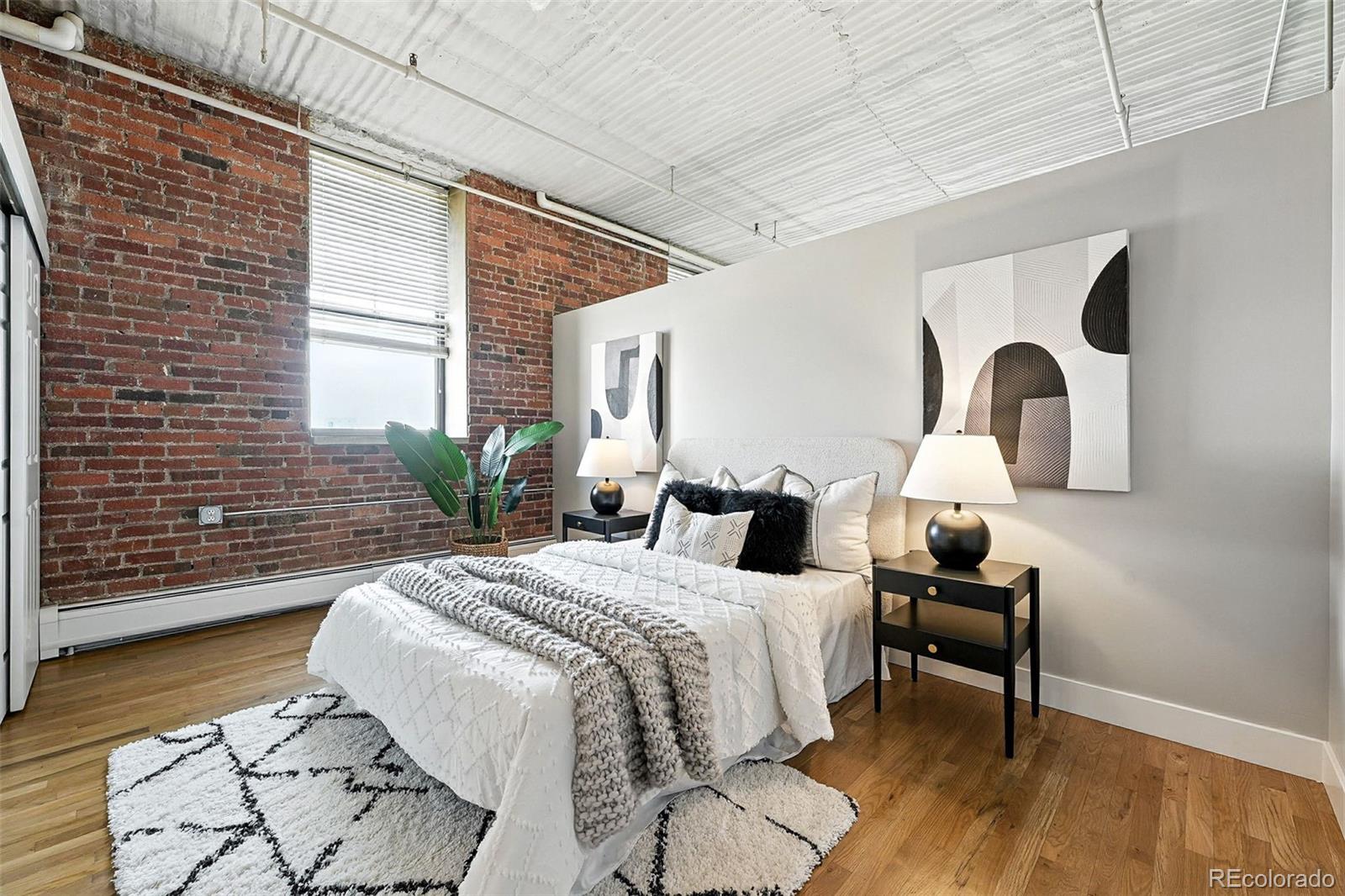 2261 Blake Street, Unit 3E Denver, CO 80205 - Photo 26 of 46 a bedroom with a bed and a potted plant