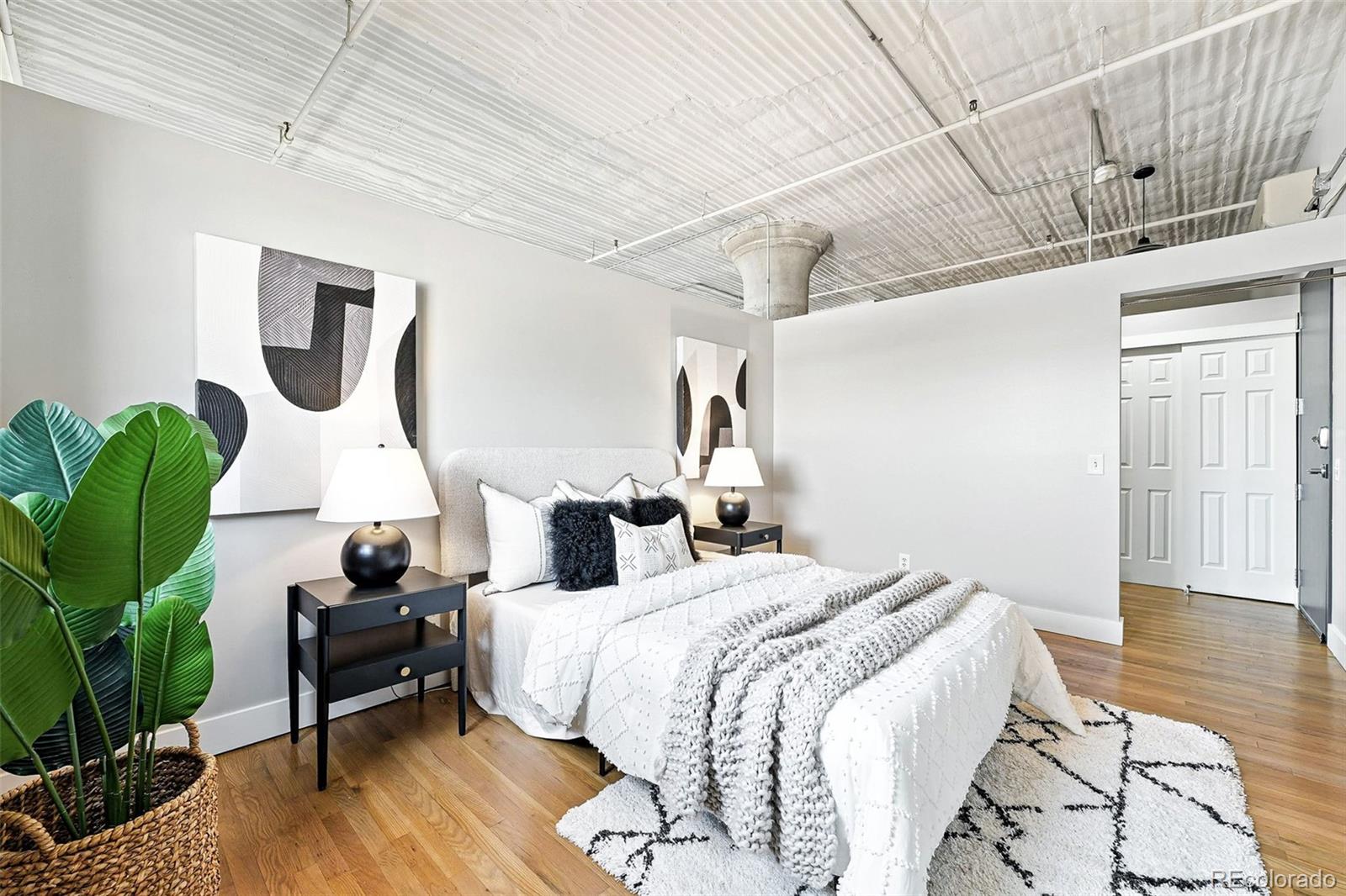 2261 Blake Street, Unit 3E Denver, CO 80205 - Photo 27 of 46 a bedroom with a bed wooden floor and window