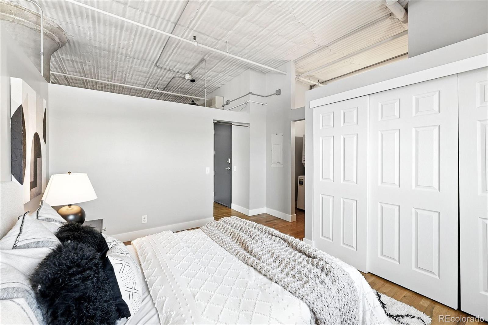 2261 Blake Street, Unit 3E Denver, CO 80205 - Photo 28 of 46 a bedroom with a bed and a chandelier