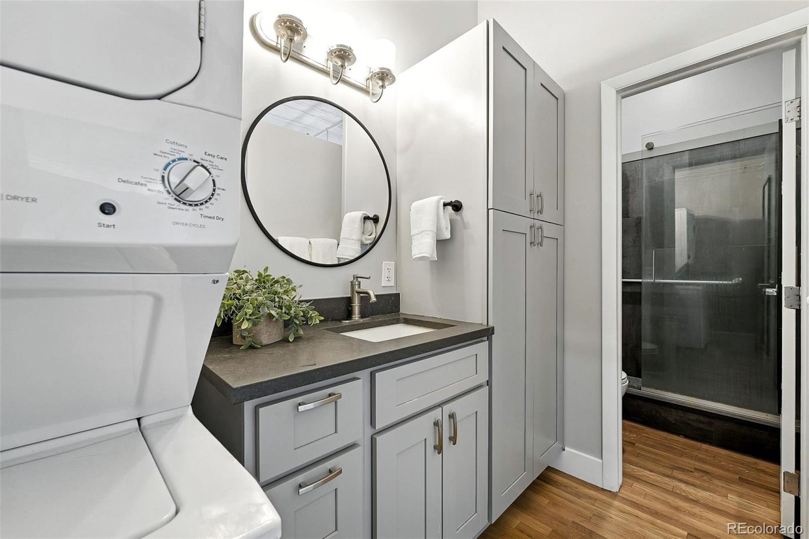 2261 Blake Street, Unit 3E Denver, CO 80205 - Photo 30 of 46 a bathroom with a granite countertop sink and a mirror