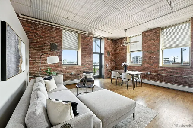 a living room with lots of furniture and view of kitchen