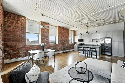 a kitchen with stainless steel appliances kitchen island granite countertop a table chairs sink and cabinets
