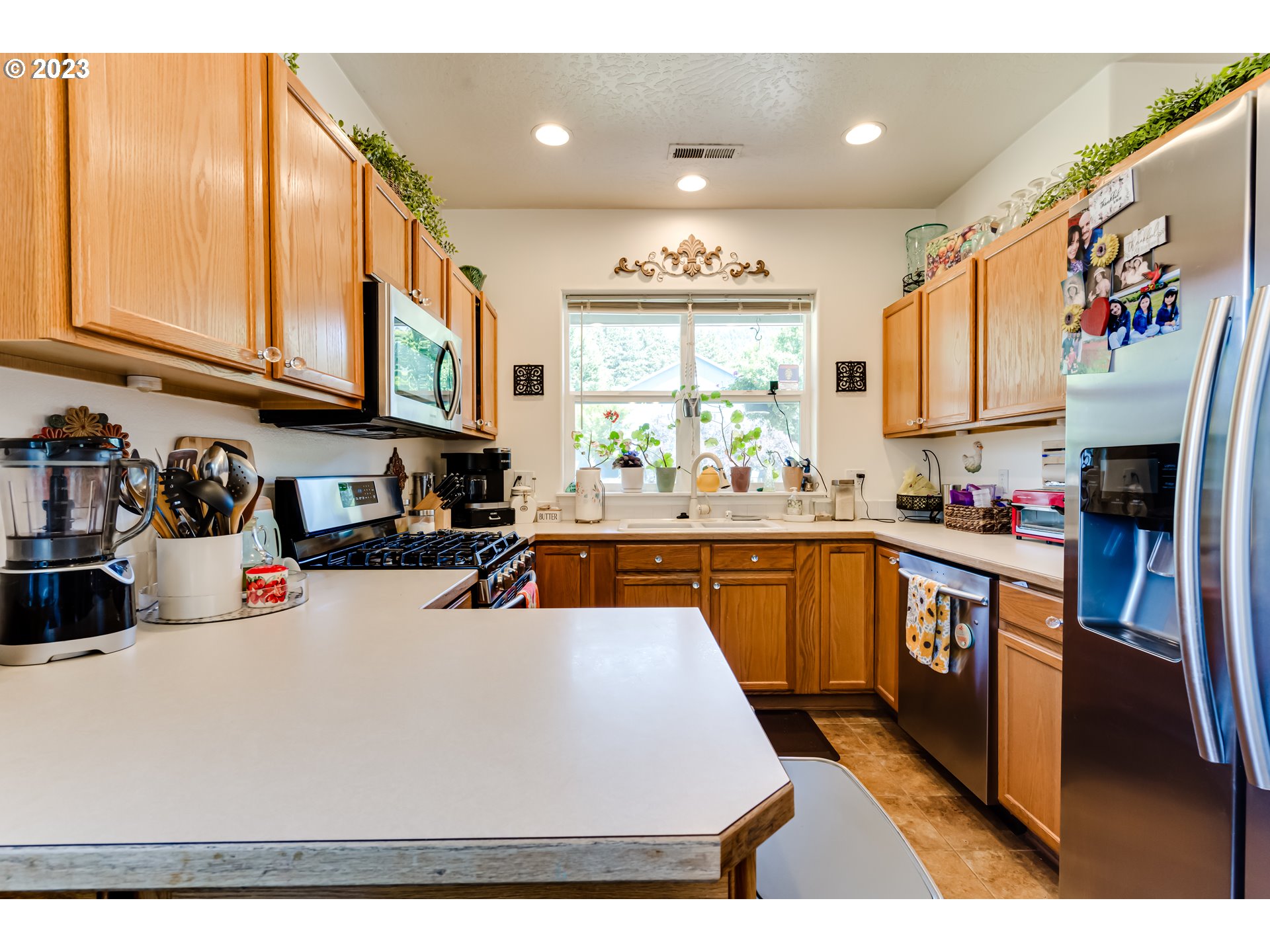 1616 South 59th Street Springfield, OR 97478 - Photo 11 of 44 a kitchen with stainless steel appliances granite countertop a refrigerator a sink dishwasher and white cabinets with wooden floor