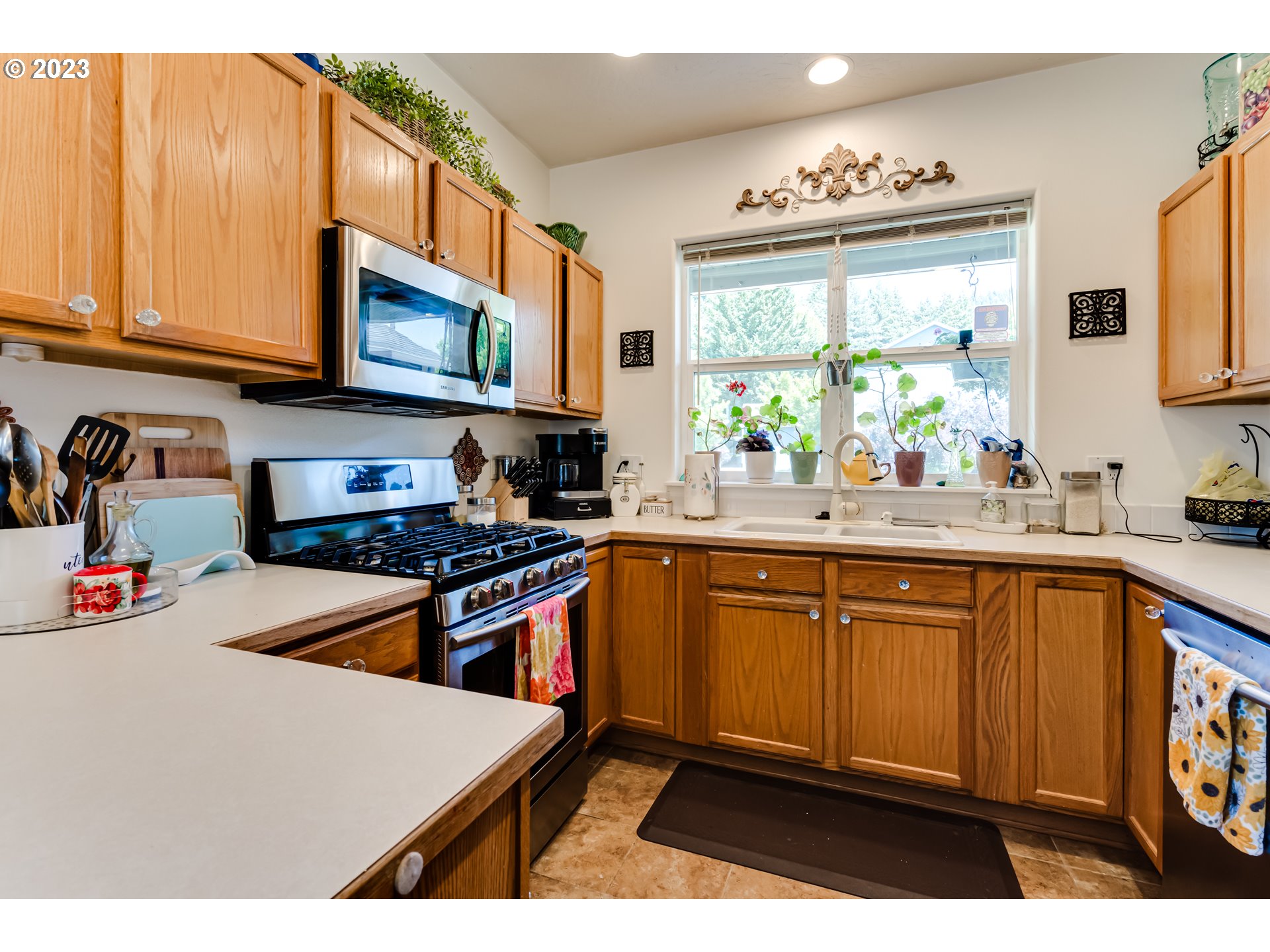 1616 South 59th Street Springfield, OR 97478 - Photo 10 of 44 a kitchen with stainless steel appliances a stove a sink a microwave and cabinets