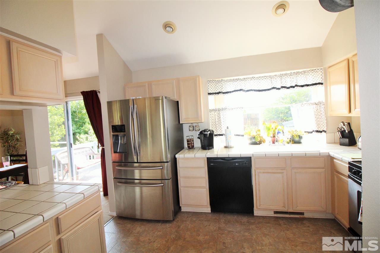 15095 Western Reno, NV 89521 - Photo 8 of 25 a kitchen with kitchen island a counter top space wooden floor and stainless steel appliances
