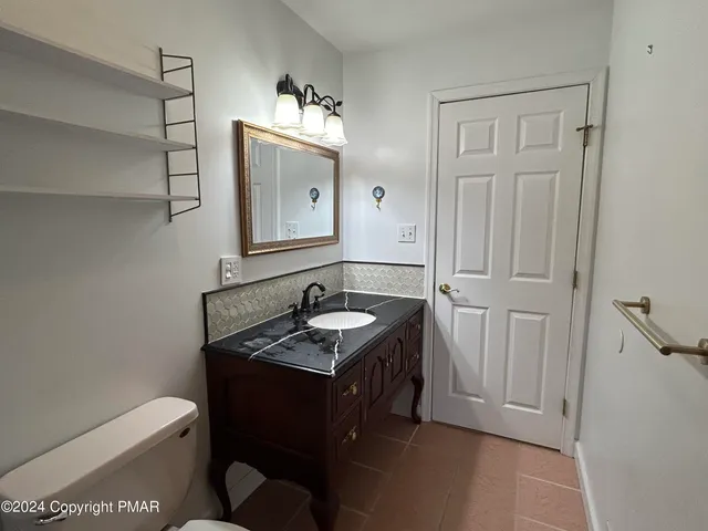 a bathroom with a sink toilet and mirror