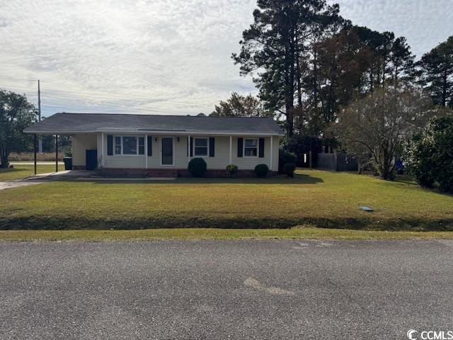 Ranch-style house featuring a front yard, an attached carport, a porch, and driveway