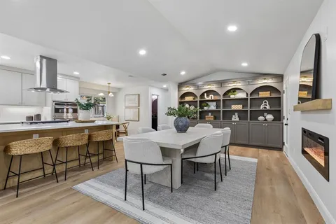 a dining room with furniture a chandelier and wooden floor