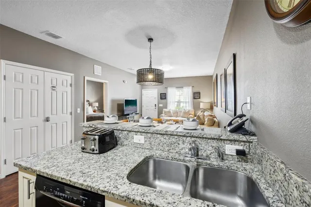 a kitchen with stainless steel appliances granite countertop a sink and a refrigerator