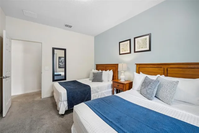 a bedroom with two beds and a lamp