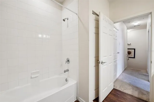 a bathroom with a bathtub shower and a sink