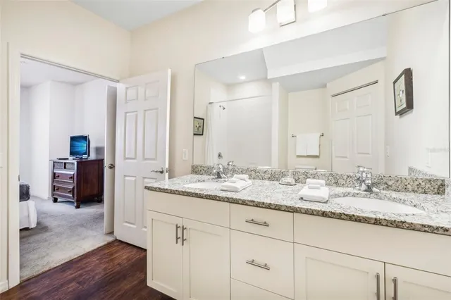 a bathroom with a granite countertop sink double and mirror