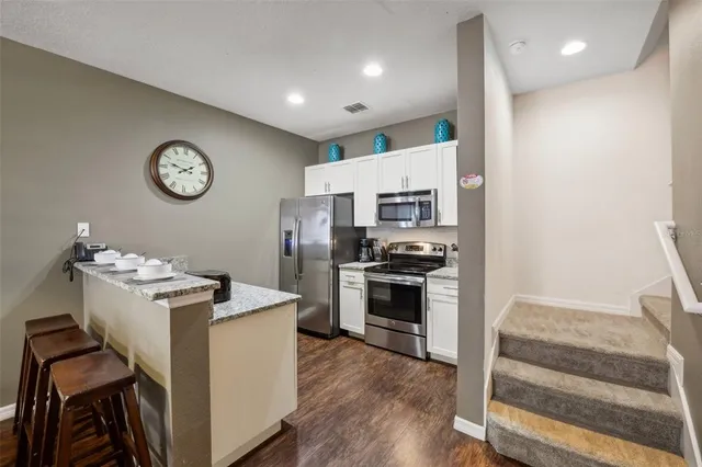 a kitchen with a refrigerator and a stove top oven