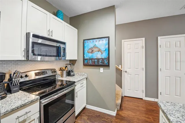 a kitchen with granite countertop a stove and a microwave