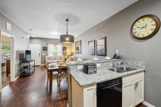 a view of a kitchen area with furniture and wooden floor