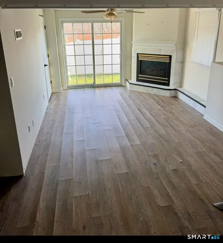 a view of empty room with wooden floor and fireplace