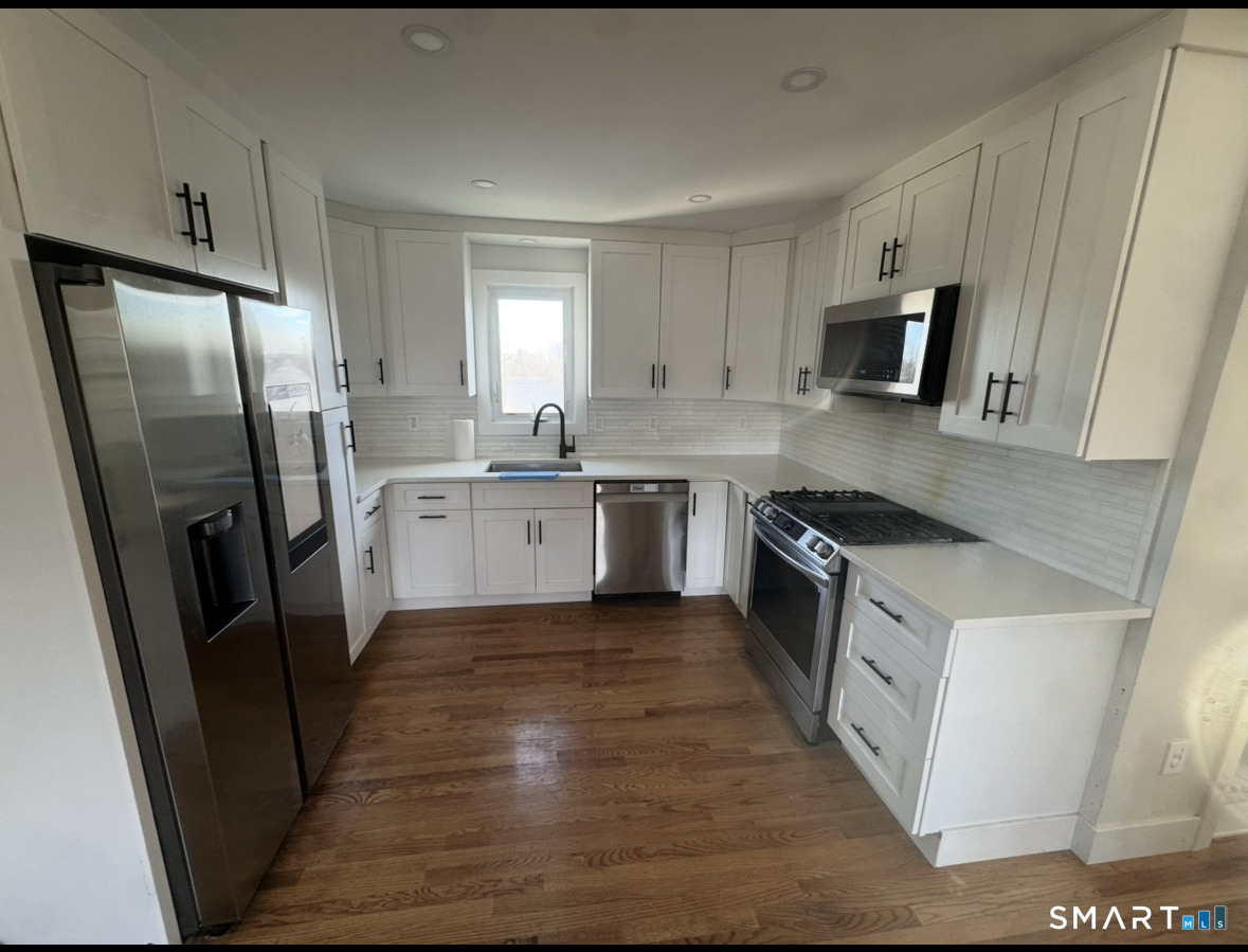 35 Knapps Highway Fairfield, CT 06825 - Photo 4 of 21 a kitchen with stainless steel appliances a refrigerator a sink a stove top oven and cabinets