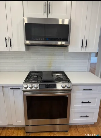 a stove top oven sitting inside of a kitchen