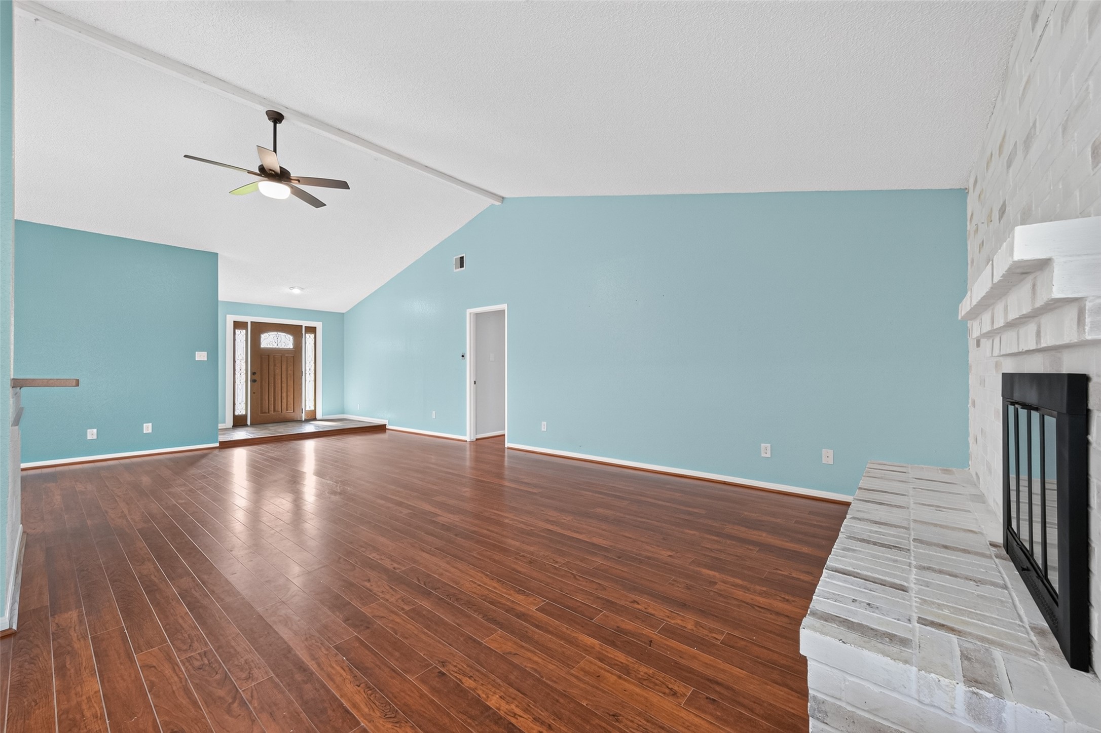 17531 Crestline Road Humble, TX 77396 - Photo 7 of 41 Step into this incredibly bright and airy living room. The space is defined by its soaring vaulted ceilings that create a grand sense of volume, complemented by sleek, polished floors that reflect the abundant natural light pouring in from large windows. A sophisticated fireplace acts as the stunning focal point of the room, adding a layer of warmth and elegance to the environment.