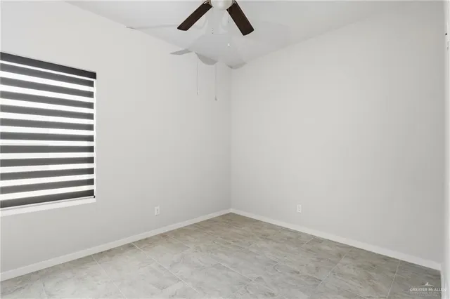 an empty room with a window and a ceiling fan